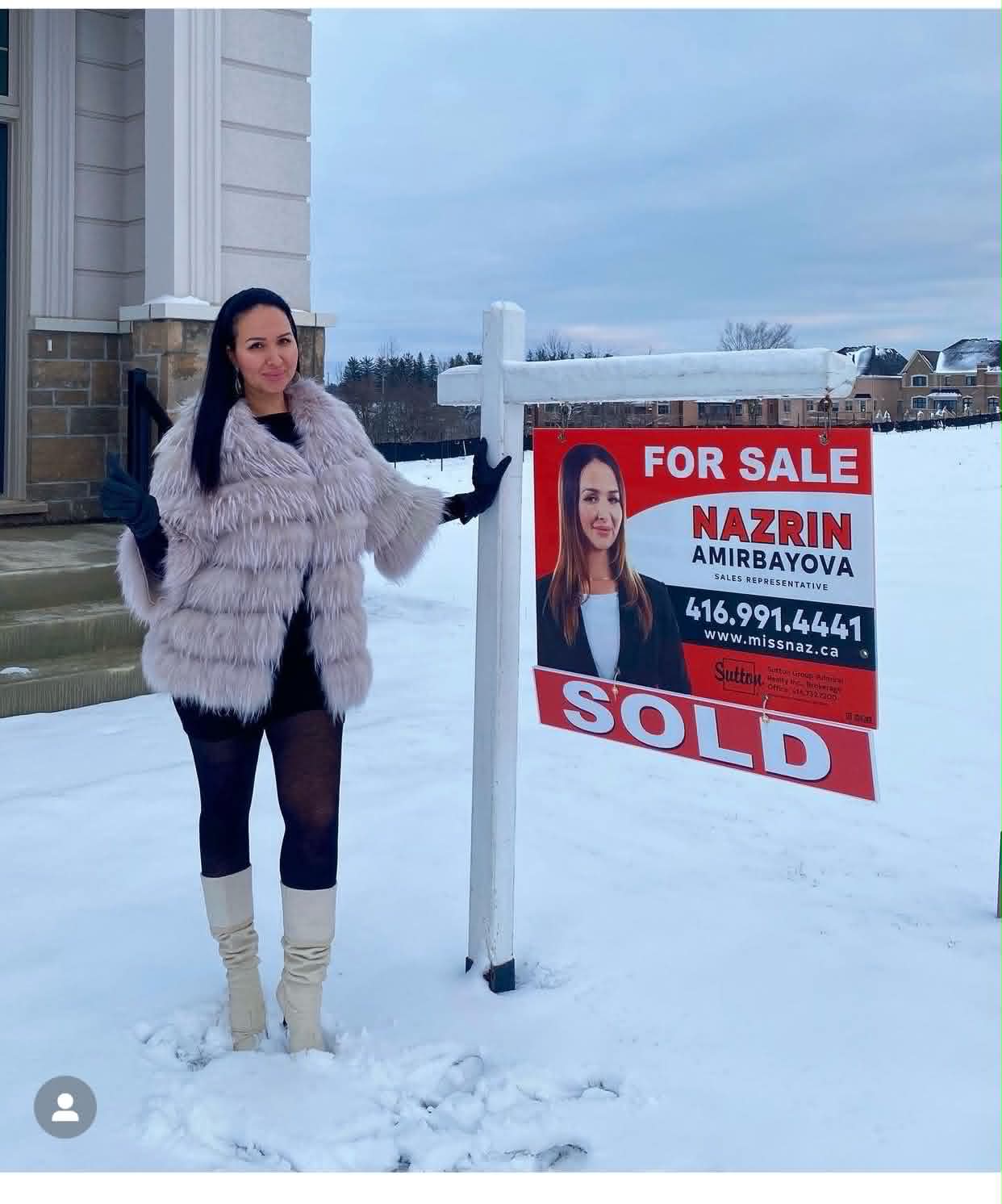 Nazrin beside a For Sale Sold sign in front of a luxury home in winter