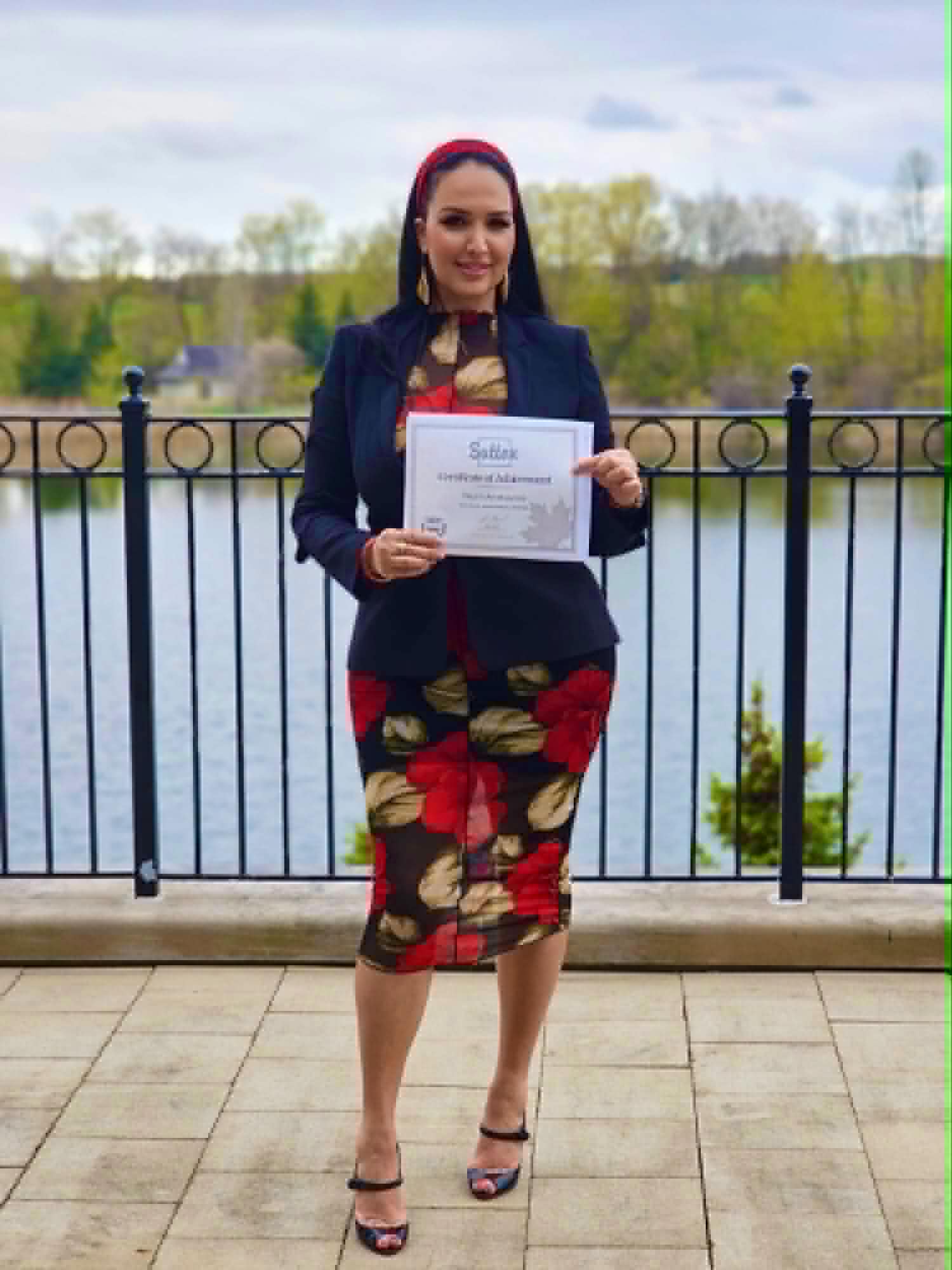 Nazrin Amirbayova holding a Sutton Diamond Award by the lake